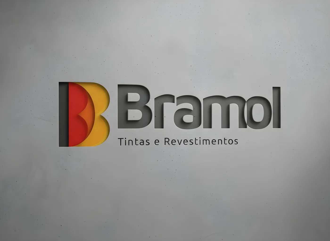 Logotipo Bramol Tintas e Revestimentos aplicado em parede de concreto.